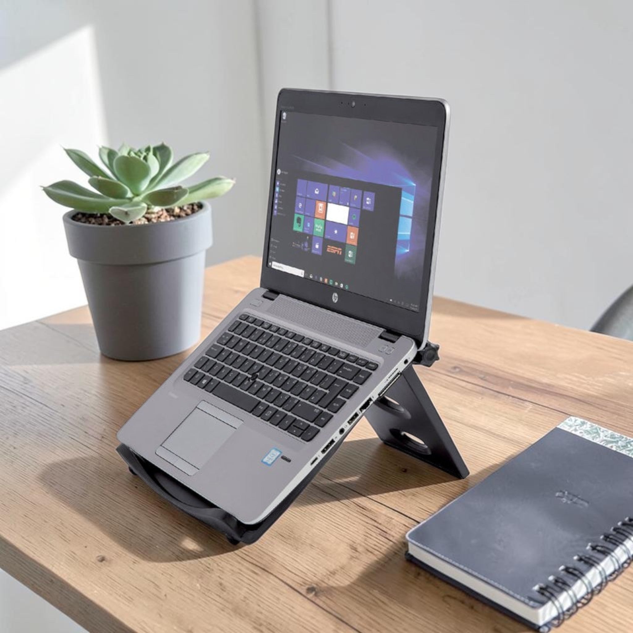 Deskshop laptopstandaard in zwart plastic, verstelbaar voor ergonomische houding en betere koeling van de laptop.